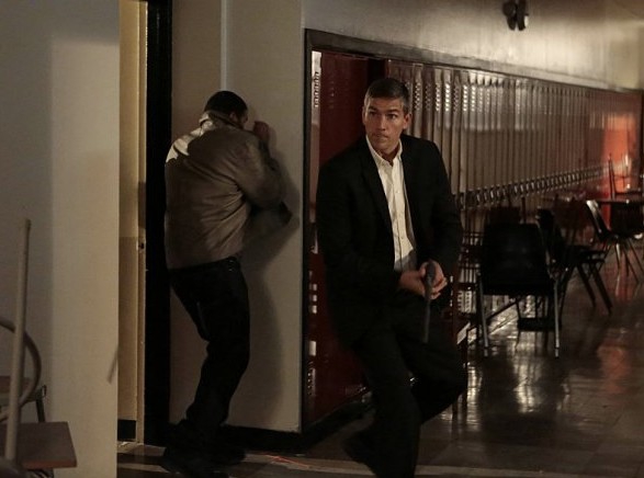 John (Jim Caviezel) protégeant un homme arrive arme au poing